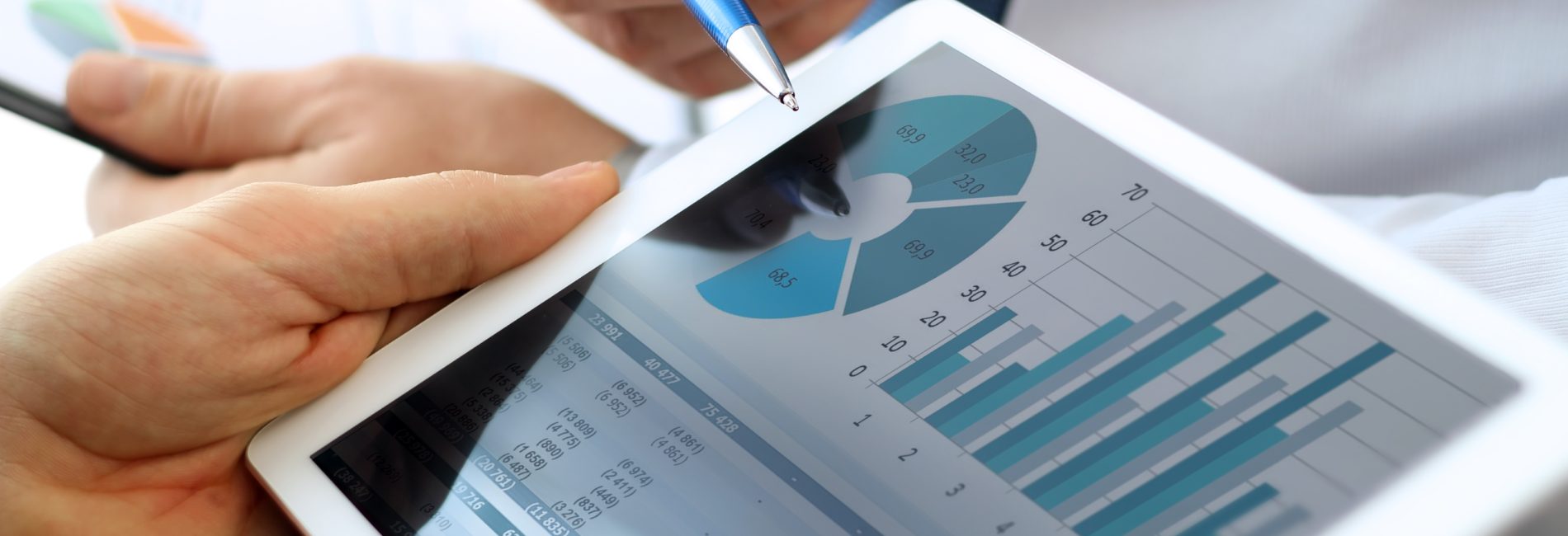 Business colleagues working and analyzing financial figures on a digital tablet