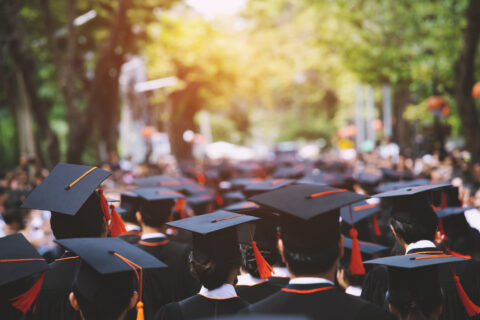 students at graduation with their caps on heading to grad school