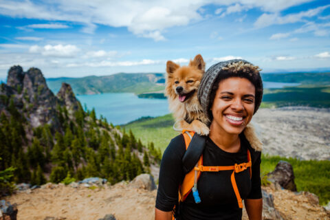 A woman hiking with her dog while on vacation