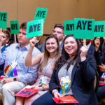 Members at Chapter Congress holding signs that read 'aye' while voting on legislation.